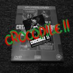 Black and white image of DVD case, with the words Crocodile 2 superimposed in red and green