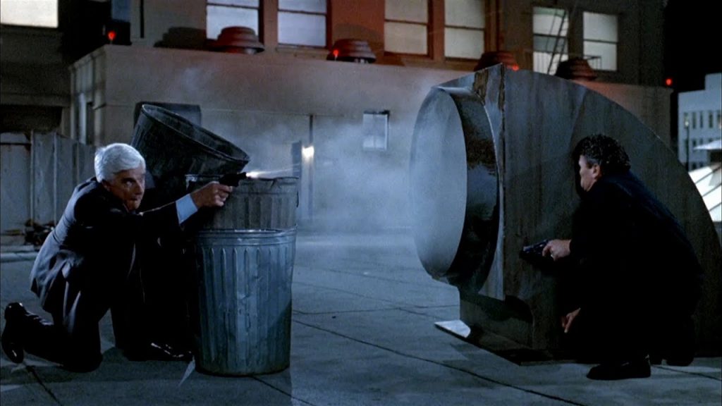 Leslie Nielsen in a comedic, close proximity shootout from the film Naked Gun 2.